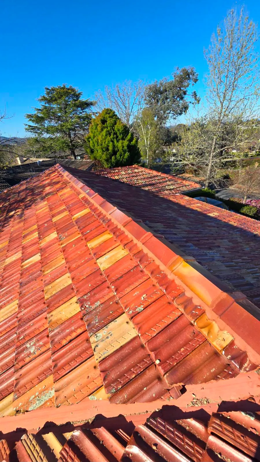 Roofing workers repairing tiles on a residential roof